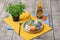 Top view of a cute dinner set on a wooden background. A colorful composition of a plate, orange bottle, and a green