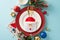 Top view of cutlery pocket, elegant plates, napkin, cozy mug, festive baubles, frost-kissed fir twigs, berries, blue backdrop