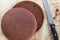 Top view of cutted in half by knife baked chocolate sponge cake on the wooden background