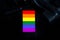 Top view dark tone LGBT grooming concept with image of a LGBTQ+ flag Pride symbol on black table background.