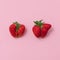 Top view of deformed strawberries on soft pink background. Ugly food movement idea