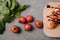 top view of delicious bruschetta on wooden board, basil and fresh tomatoes on grey