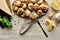 Top view of delicious cooked escargots with lemon slices, parsley, black peppercorn and tweezers on stone background.