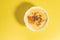 Top view of delicious custard with cinnamon in a bowl on a yellow background