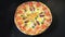 Top view delicious pizza, which rotates natals. Pizza with sausage, tomatoes and mushrooms.