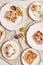 Top view of delicious plum cakes with crumbles and ice cream on plates on a white table