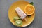 top view of delicious popsicle with slices of orange and kiwi on yellow plate