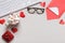 Top view of the desktop. Glasses keyboard marshmallow gift envelope with valentine`s day note on gray table. Flat lay copy space