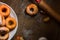 Top view detail on a bunch of fresh homemade donuts (doughnuts) on a white plate, with sugar bowl, rolling pin