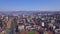 Top view of developed city on the background of mountainous landscape. Clip. Beautiful panorama of large city in valley