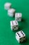 Top view of dice with the number six in the foreground focused, and four dice out of focus in the background on green mat