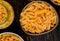 top view of different macaronis as spaghetti rotini and other types in bowls and jar on wooden background