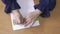 Top view of disabled blind person woman hands writing braille text on paper by using slate and stylus tools making embossed