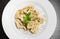 Top of view of dish of italian swivels pasta with porcini mushrooms and sauce bechamel with pepper