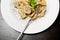 Top of view of dish of italian swivels pasta with porcini mushrooms and sauce bechamel with pepper near fork