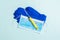 Top view of disposable surgical mask, pair of latex medical gloves and syringe on blue background. Virus protection concept with