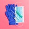 Top view of disposable surgical mask, pair of latex medical gloves and syringe on pink background. Protect your health concept