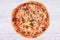 Top view of domestic pizza on white wooden background