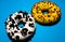 Top view on donuts or doughnuts with white and yellow frosting and decorated with crumbled cookie and sprinkle topping on blue