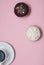 Top view Doughnuts with Chocolate and White Icing and cup of Coffee, on Pastel Pink Background. Sweet Dessert Donuts with Copy Pas