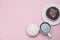 Top view Doughnuts with Chocolate and White Icing and cup of Coffee, on Pastel Pink Background. Sweet Dessert Donuts with Copy Pas