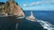 Top view of dramatic landscape of rocky island and lighthouse in sea. Clip. Cinematic fairy-tale landscape of rocky cape