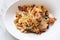 Top view of Dried Spaghetti Chili Bacon served in white bowl plate on marble table