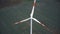 Top view drone tilts down directly above windmill turbine with red blade stripes, alternative energy sources concept.