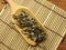 Top view of dry mugwort on spoon on bamboo mat. Chinese herbal medicine.