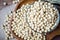 Top view of dry organic soybean seed pile in glass bowl in dark tone