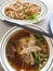 Top view of duck noodles in brown soup and boiled duck intestine