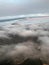 Top view of the earth from the porthole, the windows of the aircraft on the wing with engines, turbines and white fluffy, rain clo