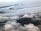 Top view of the earth from the porthole, the windows of the aircraft on the wing with engines, turbines and white fluffy, rain clo