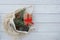 Top view of eco cotton bag and christmas stuff look out of it. Fir tree branches, cones, giftbox  with ribbon on white wooden back