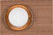Top view of an empty east style painted teacup on a saucer located on a wooden bamboo mat
