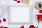 top view of an empty picture frame with a gift box ball of rope red color roses small postcard on white background with copy space