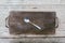 Top view of an empty rustic wooden cutting board with a silver spoon and knife cut marks
