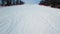 Top view of empty ski slope in winter. Stock footage. Beautiful deserted ski track near forest on winter evening day