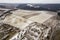 Top view of empty snowy fields and woody hills on cloudy sky background. Aerial drone photography, winter landscape