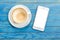 Top view empty white coffee cup (latte coffee) and smartphone wi