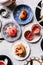 Top view of English afternoon tea set including hot tea, pastry, scones, mousse and cutlery on marble top table