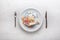 Top of view euro banknotes on white plate with fork and knife