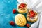 Top view of exotic dessert with mango and cheese mousse decorated with strawberry with white napkin on light blue background