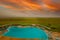 top view of exotic swimming pool in savannah near safari hotel at sunrise