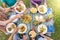 Top view of family sitting at wooden table having dinner. They have plates full of food and glasses with drinks.