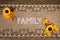 Top view of the Family word and artificial flowers on embroidered linen fabric
