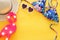 Top view of fashion female swimsuit bikini and hat over yellow wooden background. Summer beach vacation concept.