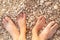 Top view the feet of adult and a child on the gravel pebble beach. Father and daughter love. Flat design, summer holidays creative
