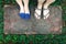 Top view feet of male and female couple lover standing on stone floor among little green grass garden. hipster style