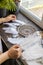 Top view female craftsman hands creating traditional dreamcatcher choosing material at workshop